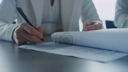 Téléchargez les photos : Successful ceo signing contract in office. Closeup woman hands holding pen write on legal papers. Unknown insurance agent manager checking agreement put signature. Corporate negotiations concept. - en image libre de droit