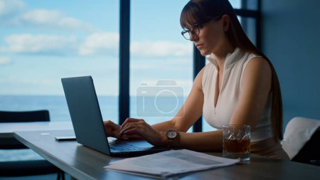 Photo for Woman professional surfing laptop at sea panorama window. Office manager working analyzing data online. Focused beautiful freelancer look computer screen reading report. Financial consultant concept. - Royalty Free Image