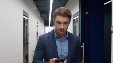 Photo for Irritated man making call in office. Dissatisfied executive rejecting ideas resolving problems in mobile conversation. Handsome nervous manager walk hallway talking phone. Upset bank corporate client - Royalty Free Image