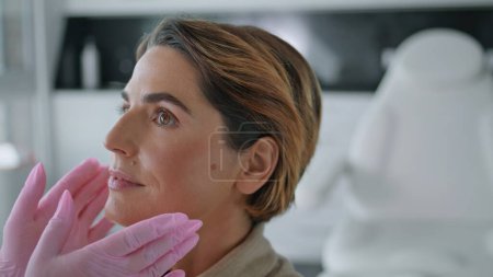 Photo for Unknown doctor in gloves making facial examination to elegant woman closeup. Cosmetologist hands touching face lady client checking skin health. Beautician preparing patient to beauty salon procedure. - Royalty Free Image