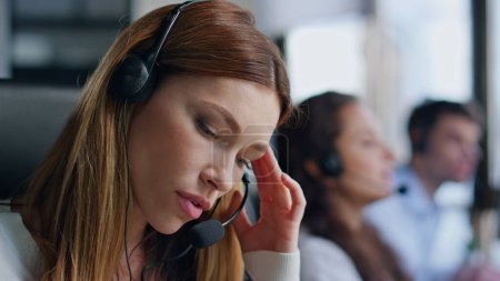Nervous telemarketing assistant talking headset closeup. Annoyed woman talking consulting client in call center. Angry customer service agent give instructions on helpline. Tired employee at work