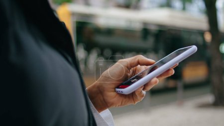Photo for African american woman hands swiping on smartphone screen outdoors close up. Unknown young girl holding modern mobile phone surfing in internet. Female fingers touching scrolling telephone on street. - Royalty Free Image