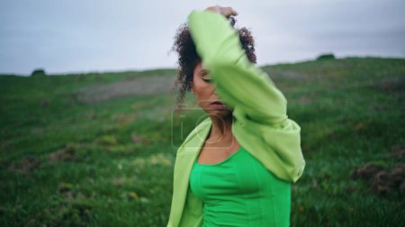 Photo for African american professional dancer performing contemporary dance on cloudy nature close up. Confident focused woman dancing modern choreography on green grass field. Curly girl moving expressively. - Royalty Free Image