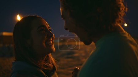 Guy touching girl nose on romantic date night close up. Gentle man kissing girlfriend expressing feelings at evening landscape. Enamoured teenagers having fun enjoying love moment. Nature leisure time