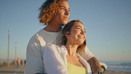 Carefree sweethearts cuddling at summer nature close up. Smiling man kissing positive woman caressing head tenderly on beautiful marine beach. Affectionate couple enjoying moment together on seacoast 