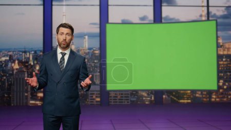 Photo for Professional newsreader talking at mockup monitor standing stage television studio. Elegant newscaster pointing to green screen displaying current information. Confident presenter hosting daily news. - Royalty Free Image