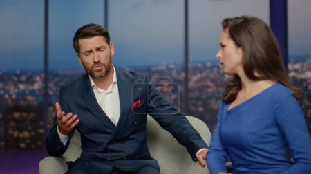 Frustrated man talking at interview tv show to sympathizer woman presenter close up. Sad bearded guy complaining at life problems business fail in air. Anchorwoman supporting listening program guest.