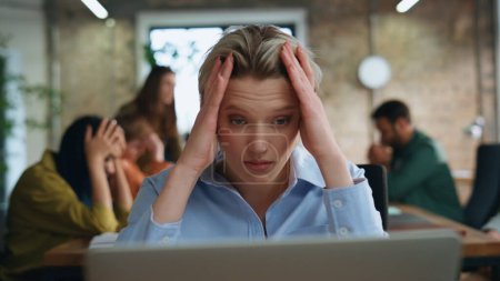 Exhausted woman looking laptop screen reading bank notification sitting office coworking close up. Tired businesswoman receiving bad financial report. Frustrated lady unsatisfied business failure.