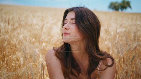 Dreaming beautiful girl resting rural nature closeup. Country lady looking distance feeling inspiration in summer wheat field. Tender woman enjoying light breath at rye countryside. Freedom concept