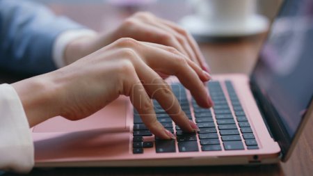 Empresaria manos pulsando teclado portátil en la oficina moderna de cerca. Mujer irreconocible escribiendo en el equipo de búsqueda de información en Internet. Chica ocupada freelancer trabajando remotamente en notebook.