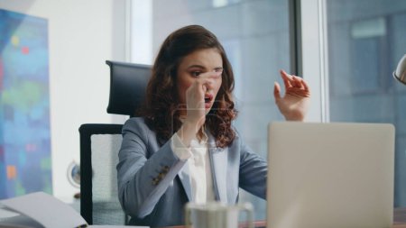Desperate woman manager looking laptop screen shocked by business loss sitting modern office desk close up. Confused businesswoman feeling exhausted receiving bank notification. Work crisis concept.