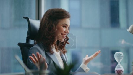 Excited businesswoman talking webcam laptop sharing business success sitting office close up. Happy beautiful lady boss talking emotionally at video meeting. Smiling girl manager have videoconference