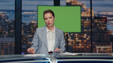 Photo for Female newscaster reporting chromakey screen news at studio closeup. Professional anchor woman broadcasting day events doing showing gesture. Lady presenter talking at live tv channel studio alone - Royalty Free Image