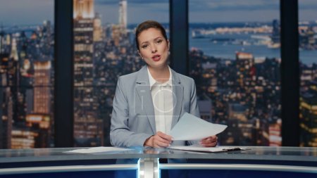 Photo for Smiling journalist presenting breaking news at night studio closeup. Elegant newsreader lady speaking at newscast television. Anchor woman gesturing hands talking about world political situation - Royalty Free Image