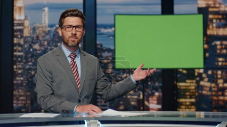 Professional television presenter ending evening newscast standing modern studio. Confident bearded man host saying goodbye to viewers in newsroom. Anchorman working daily world events programme
