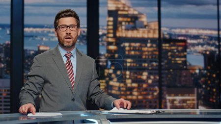 Photo for Smiling newscaster reporting at newscast modern multimedia channel closeup. Confident newsreader covering daily news in television studio. Bearded anchor man talking business information in air - Royalty Free Image