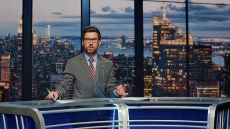 Photo for Bearded anchor man talking at newscast modern multimedia channel closeup. Confident newsreader covering daily news in television studio. Serious newscaster reporting business information in air - Royalty Free Image