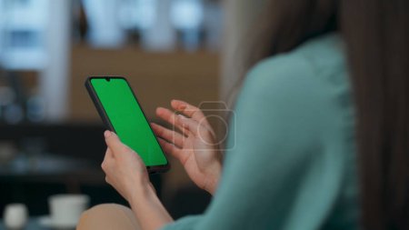 Closeup chroma key cellphone in businesswoman hands at office. Unknown executive typing analyzing company report at mockup device. Unrecognized manager examining watching weekly tasks on green screen