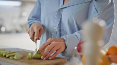 Loving partners cooking together at home cozy romantic morning closeup. Relaxed beautiful woman slicing tasty apple for healthy breakfast. Happy man hugging beloved wife in modern kitchen. Love couple