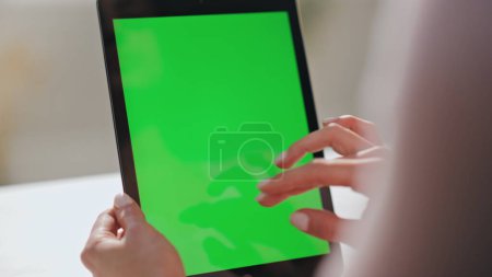 Frau Hände wischen Green Screen Tablet beobachten Social Media zu Hause aus nächster Nähe. Unbekannte Geschäftsfrau benutzt Computer-Attrappen, die das Scrolldisplay im Haus berühren. Dame arbeitet an Chroma-Schlüsselgerät.