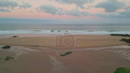 Drohne Sonnenuntergang ruhigen Strand malen sanfte Meereswellen. Ruhige Landschaft, die sich in der Abenddämmerung mit weichem Sand vermischt und eine malerische, reflektierende Küste schafft. Drohne Natur Leinwand der Schönheit und Ruhe in den Abend.