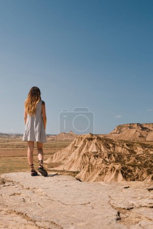 Photo for Girl with dress standing in the desert of the Bardenas Reales of Navarra in summer - Royalty Free Image