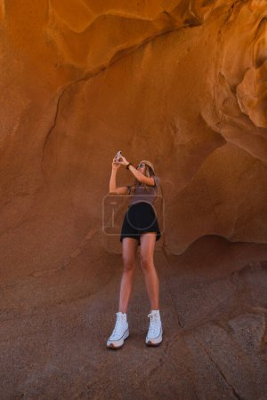 Téléchargez les photos : Fille prenant des photos des formations rocheuses du canyon Las Peitas à Fuerteventura - en image libre de droit