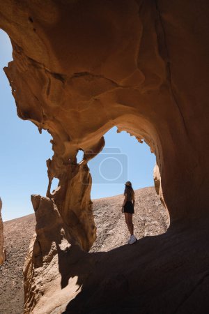 Téléchargez les photos : Femme dans les formations rocheuses spectaculaires d'un canyon à fuerteventura - en image libre de droit