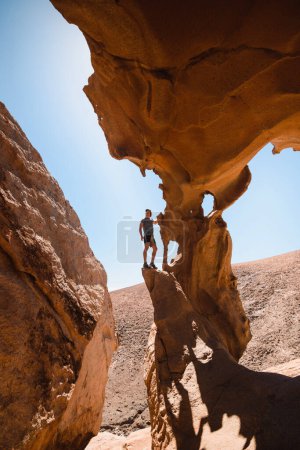 Photo for Man in the spectacular rock formations of a desertic sandstone canyon in Fuerteventura - Royalty Free Image