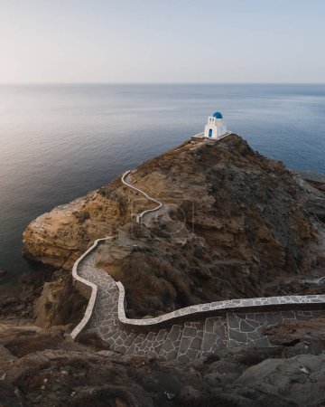 Foto de Bonita vista de la iglesia de Kastro en la cima de un acantilado rodeado por el mar y con un sendero de acceso retorcido. En la isla griega de Sifnos en las Cícladas - Imagen libre de derechos