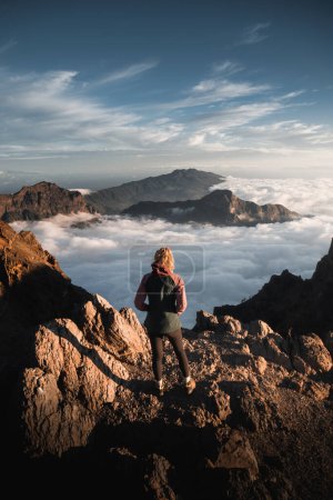 Foto de Mujer montañera observando el paisaje de la Caldera De Taburiente desde la cima del Roque De Los Muchachos al atardecer en la isla de La Palma - Imagen libre de derechos