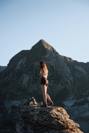 Téléchargez les photos : Jeune fille regardant la montagne grimpé sur un rocher lors de son voyage à travers les pyrénées - en image libre de droit