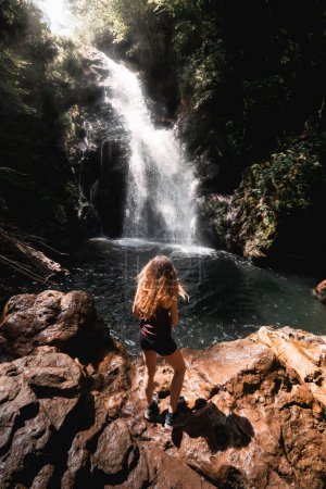 Foto de Mujer joven disfruta de las vistas de la cascada de Xorroxin y la piscina en el valle del Baztan en verano - Imagen libre de derechos