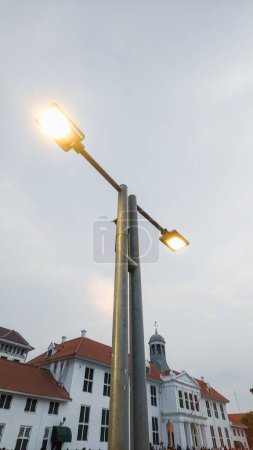Niedrigwinkel-Ansicht moderner LED-Straßenlaternenmast in der Nähe eines niederländischen Kolonialgebäudes im historischen Viertel von Nord-Jakarta, Indonesien