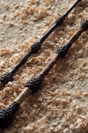 Photo for Two elderberry magic wands lie on wooden shavings in Ollivanders workshop close-up upright up. Harry Potter themed props - Royalty Free Image