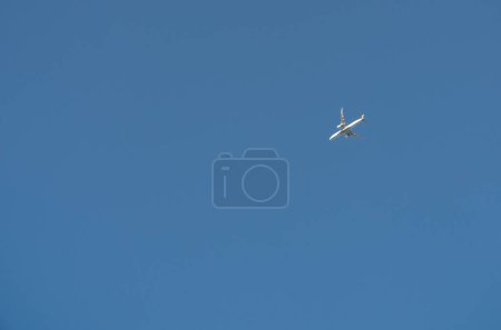 Téléchargez les photos : L'avion dans un ciel bleu clair vole de droite à gauche. Transport de passagers ou de marchandises. Il y a de l'espace pour ajouter du texte. - en image libre de droit
