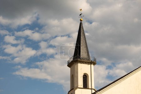 Friedrichsdorf, Hochtaunus, Hessen, Germany Mai 2022. Church tower of the Protestant church in Friedrichsdorf. Blue sky with clouds. 