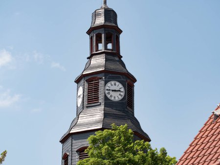 Photo for Close up church tower with clock. ancient clock with old clock-face. Sunny day with blue sky and few clouds. - Royalty Free Image
