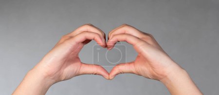 Photo for Hand shapes a heart. Body part, hand and fingers shapes a heart. Valentine and romantic gesture. - Royalty Free Image
