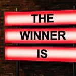 The winner is. Black letters on a light box. Illuminated sign in front of a red brick wall. Competition, achievement, success, trophy, winning, victory, prize, goal line, award ceremony and championship. 3D illustration