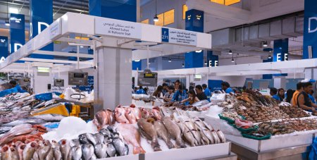 Photo for Dubai, Deira, United Arab Emirates - April 2023: Waterfront fish market. Retailers offer fresh fish and crustaceans at their stalls in the market. Different kinds of fish on ice. Cod, Hamour fish, sea bream, Shari fish, kingfish, prawn and shrimps. - Royalty Free Image