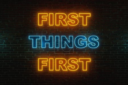 First things first. Brick wall at night with the text "first things first" in orange and blue neon letters. Important, in order, strategy, priorety.  3D illustration 