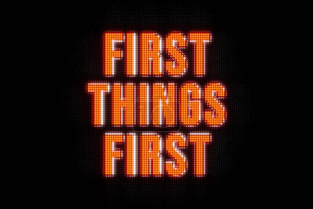 Photo for First Things First. Banner in orange capital letters. The text, first things first, illuminated. Strategy, order, sequence, advice. - Royalty Free Image