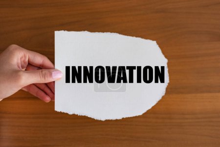 Innovation. Frau hält einen Zettel mit einer Notiz in der Hand, Innovation. Entwicklung, Fortschritt, Technologie, neue Ideen, Wissenschaft.