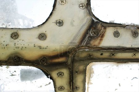 Photo for Rusty window frame of an old airplane with screws. - Royalty Free Image