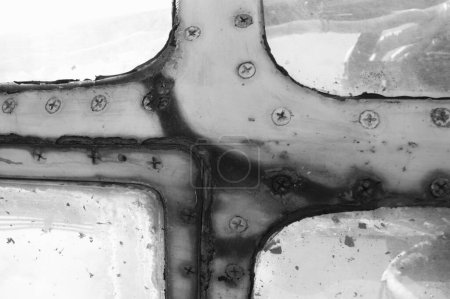 Photo for Rusty window frame of an old airplane with screws. Black and white photo. - Royalty Free Image