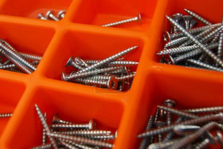 Photo for Red screw box with metallic screws. Close-up. - Royalty Free Image
