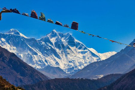 Gebetsfahnen flattern im Wind im Schatten der Gipfel des Everest und des Lhotse vom Namche Bazaar, Nepal aus gesehen