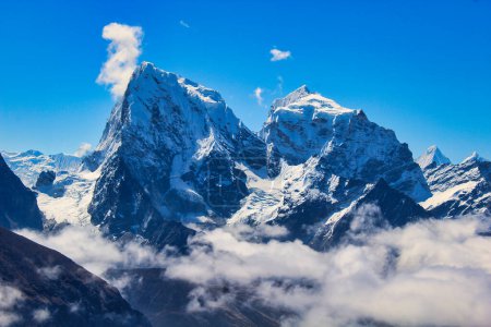 Dramatic twin peaks of Cholatse and Taboche against a bright blue sky seen from Gokyo Ri, Nepal