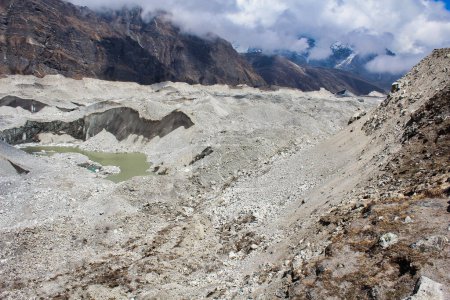 Glacier Ngozumpa, le plus grand glacier du Népal avec des débris massifs, de la pierre, de la glace et des dépôts d'argile, coule de Cho Oyu et est la source du Dudh Kosi qui parcourt plus de 1500 km jusqu'à la baie du Bengale